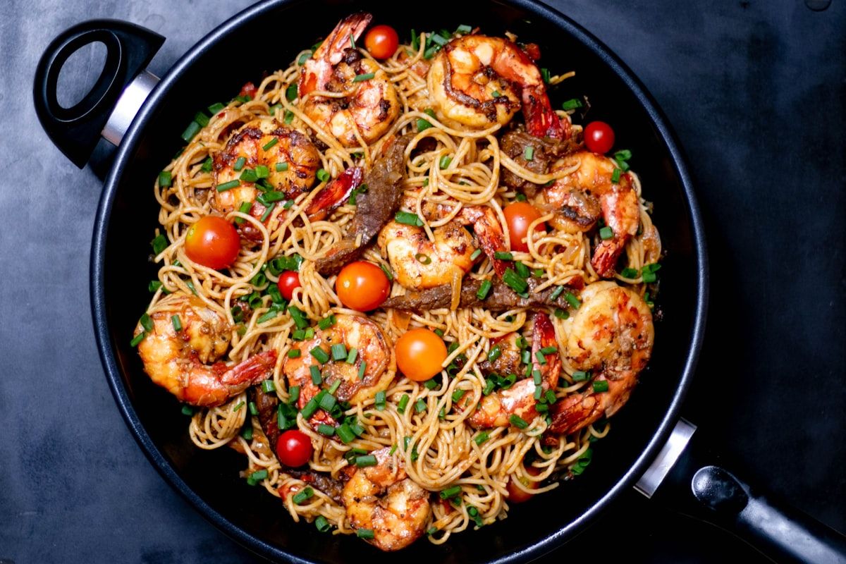 Skillet of spaghetti with seared shrimp, cherry tomatoes and chives